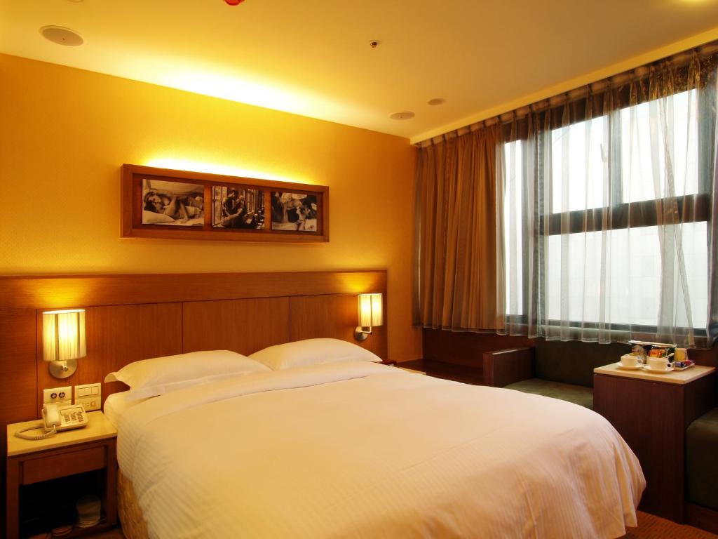台北東鑫商務旅館Eastern Star Hotel的一间设有大床和窗户的酒店客房
