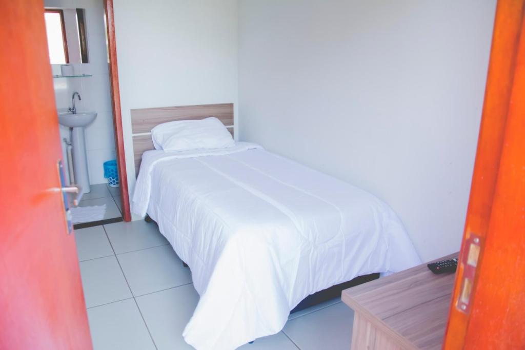马里利亚Leati's Hotel的一间卧室配有一张带白色床罩的床