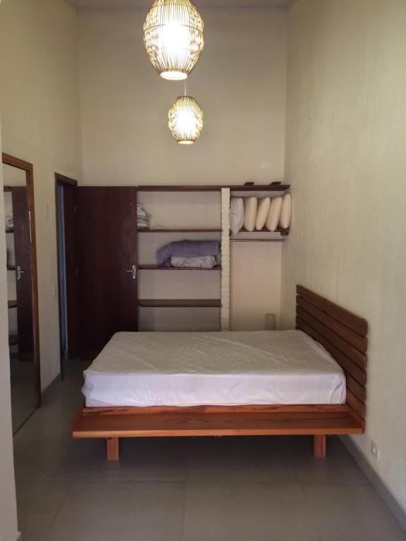 伊利亚贝拉Privacidade e Conforto no Saco da Capela的一间卧室配有一张木框床和灯