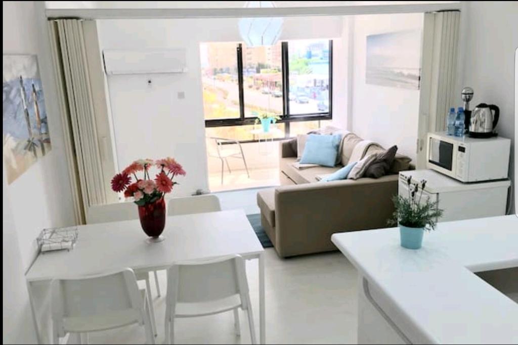 拉纳卡Bettys 1br seafront apt的客厅配有沙发和桌椅