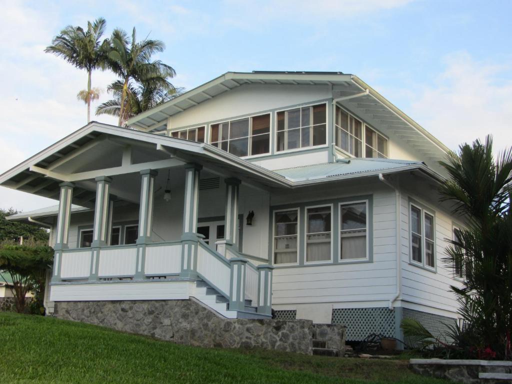 希洛Old Hawaiian Bed and Breakfast的白色的房子,设有门廊和棕榈树