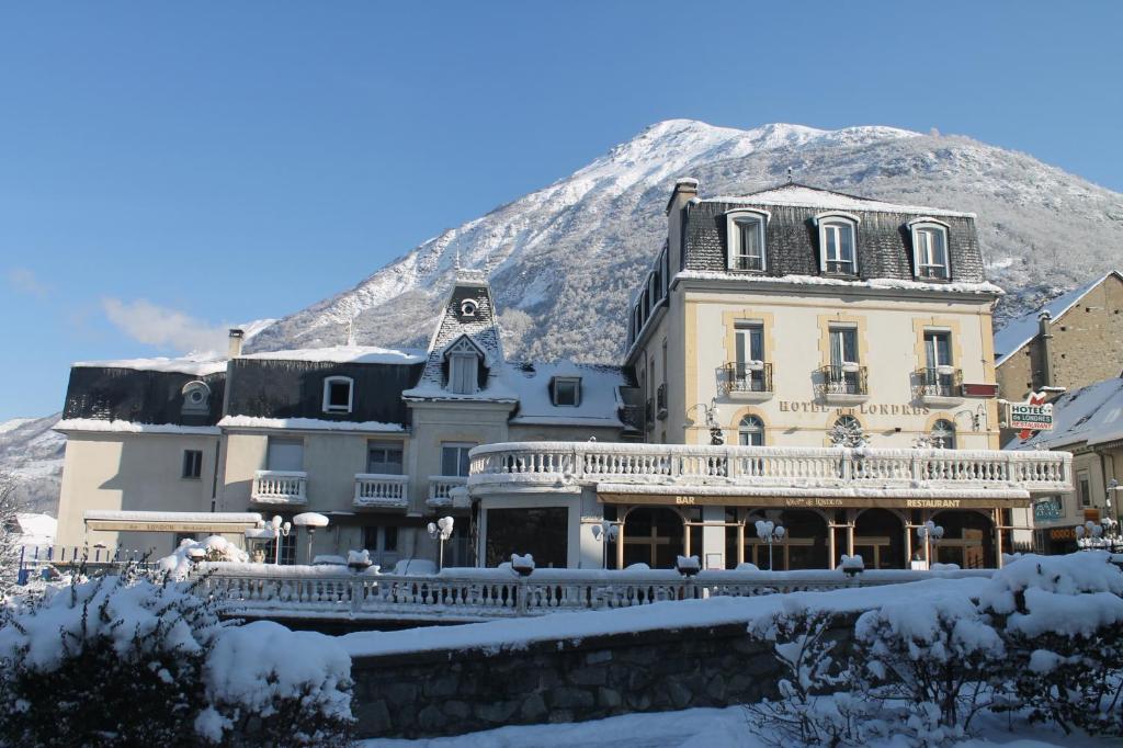吕兹-圣索沃尔Hôtel Tourmalet的一座大建筑,底楼是积雪覆盖的山