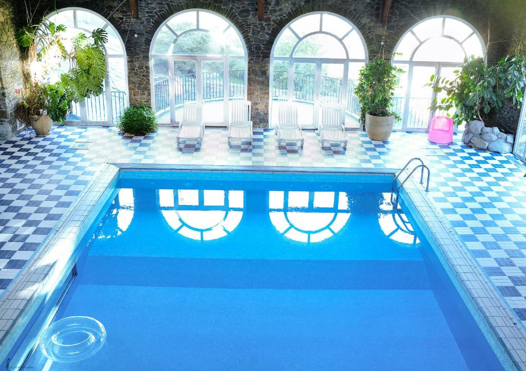 埃尔塔特Hotel Llop Gris的游泳池设有蓝色瓷砖地板和窗户