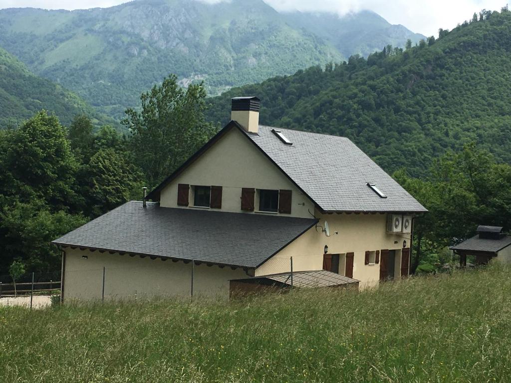 Saint-BéatGite Ballestan的山顶上的房子,背景是群山