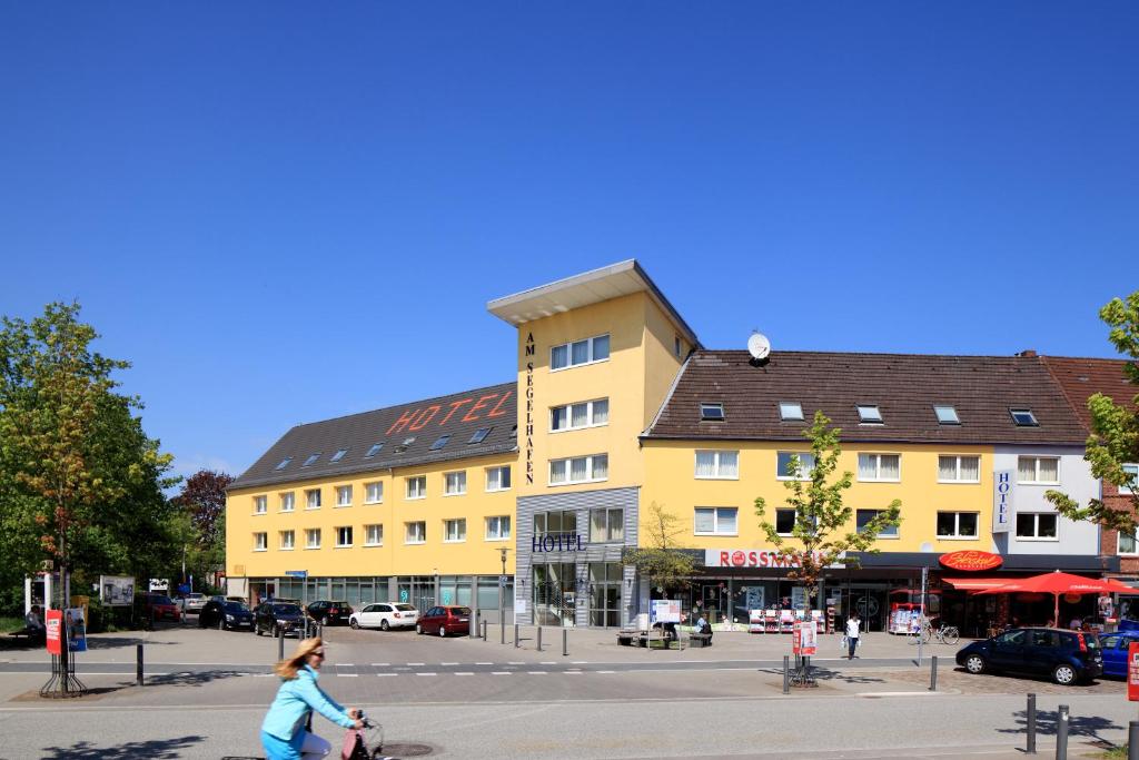 基尔泽格哈芬酒店的一位在黄色建筑前骑着自行车的女人