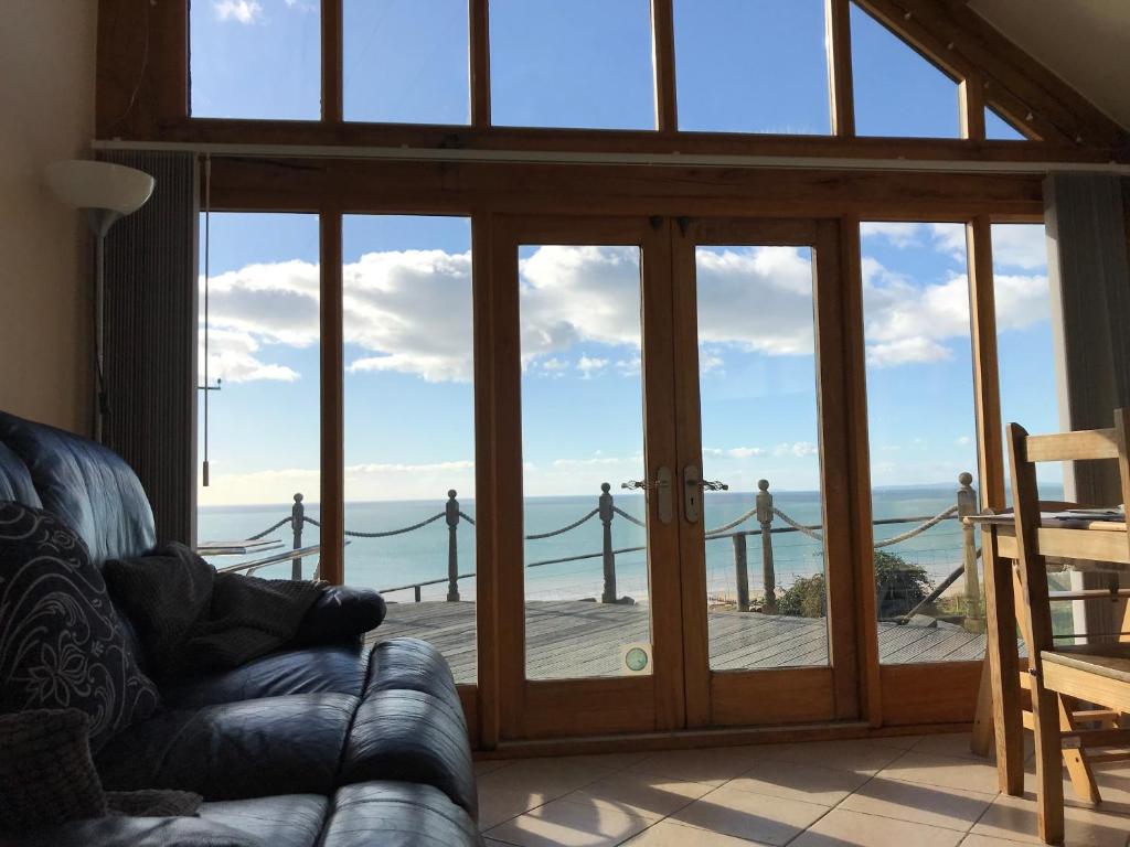 巴茅思美丽威尔士度假屋的客厅设有滑动玻璃门,享有海景
