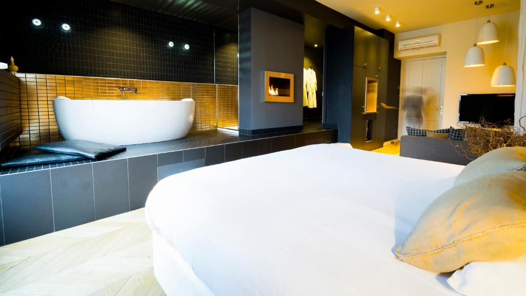 里昂MiHotel Bellecour的带浴缸和大床的浴室