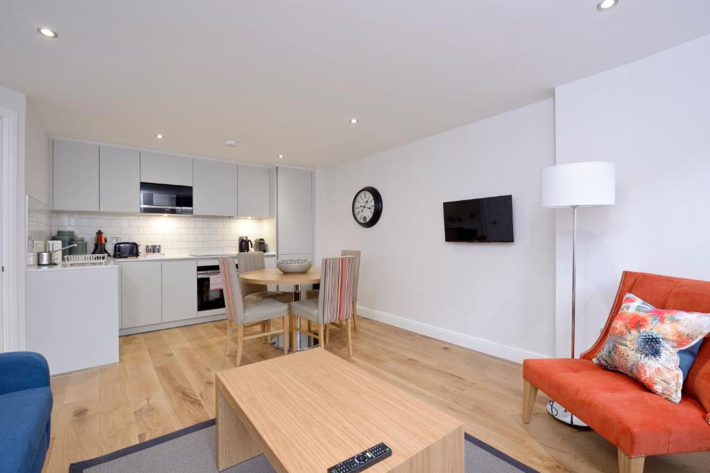 爱丁堡Destiny Scotland New Town Apartments的客厅以及带桌椅的厨房。