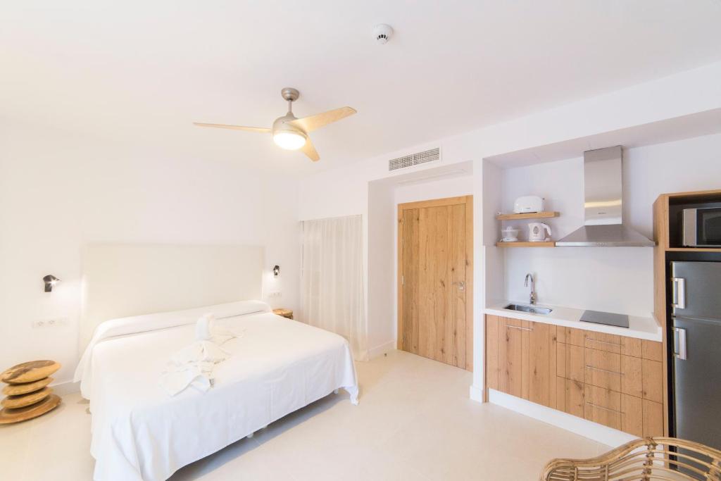 埃斯卡洛Sa Cala Suites的一间白色卧室,配有床和厨房