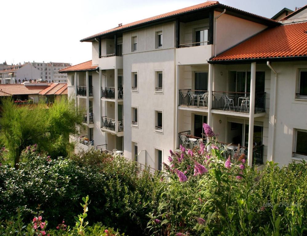 比亚里茨比亚里茨海洋酒店的白色的公寓楼,设有红色屋顶