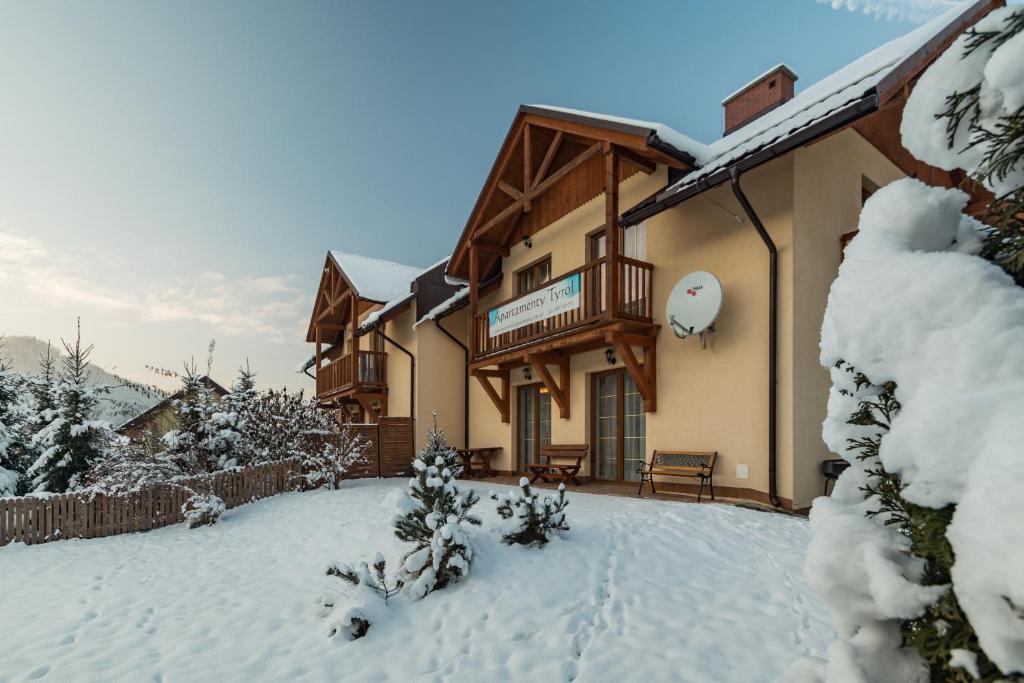 什恰夫尼察Apartamenty Tyrol的雪中带阳台的房子