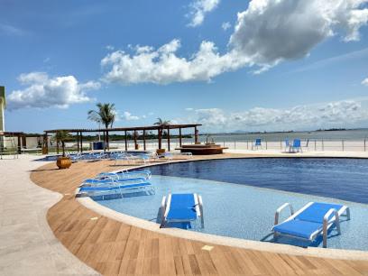 阿拉亚尔-杜卡布Golden Lake - FLX Pé na Areia 1 ARRAIAL DO CABO的一个带蓝色椅子的游泳池和海滩