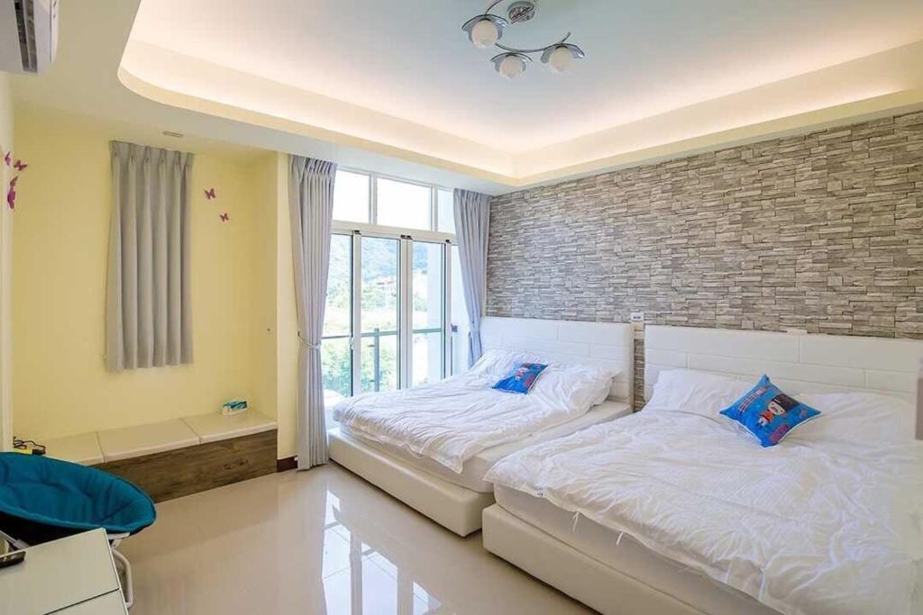 竹山綠竹筍民宿的一间卧室设有两张床和砖墙