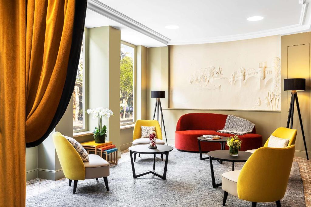 巴黎Hotel Ducs de Bourgogne的客厅配有黄色和红色的椅子和桌子