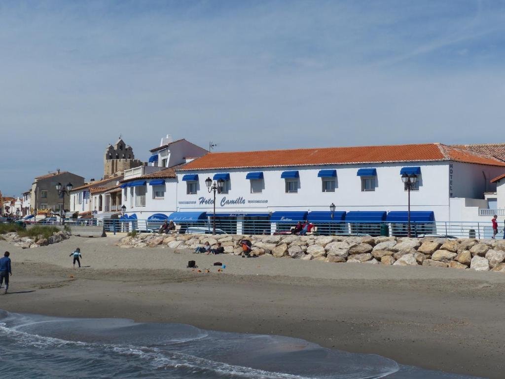 圣马迪拉莫卡米尔酒店的海滩上有人,有白色的建筑