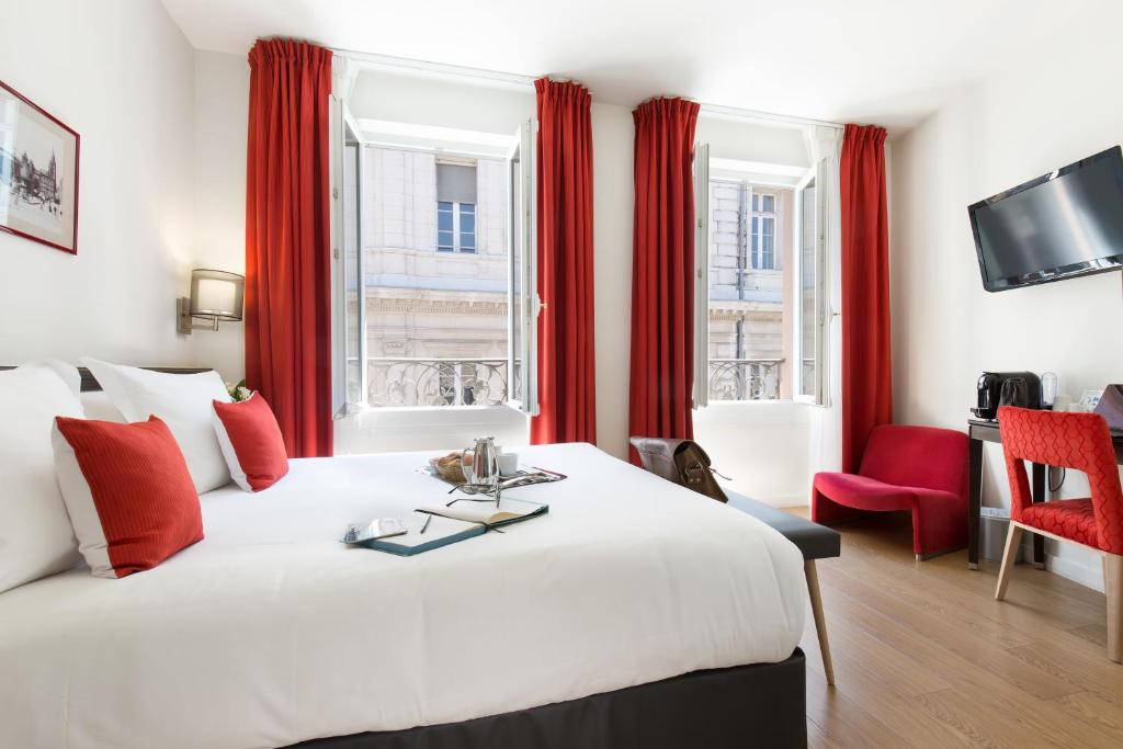 图卢兹阿尔伯特第一酒店的酒店客房设有一张大床和红色窗帘