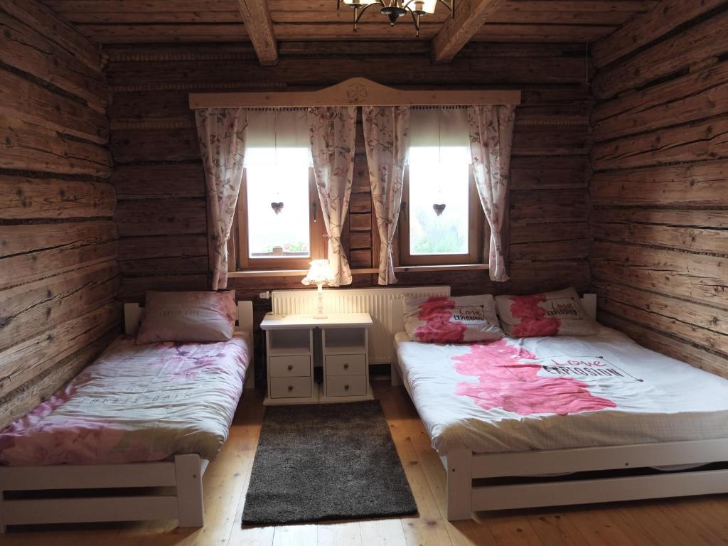 马科夫帕德哈兰斯基Chata Mioduszyna w Beskidach - drewniany dom z widokiem na Babią Górę的带2扇窗户的客房内的2张床