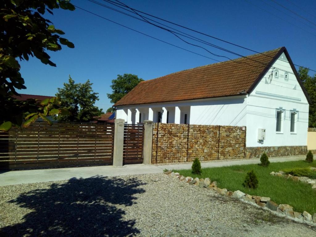 PăulişCasa Ago - Guest House的前面有栅栏的白色教堂