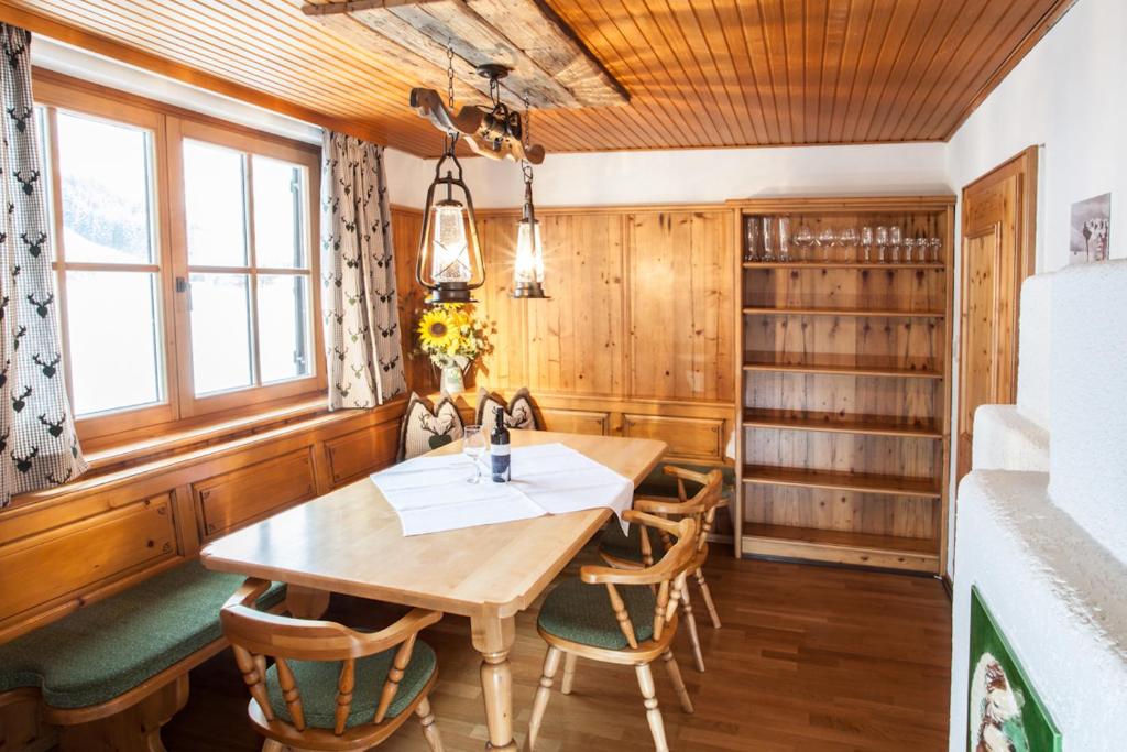 萨尔巴赫Chalet Appartement Alpenherz的一间带木桌和椅子的用餐室