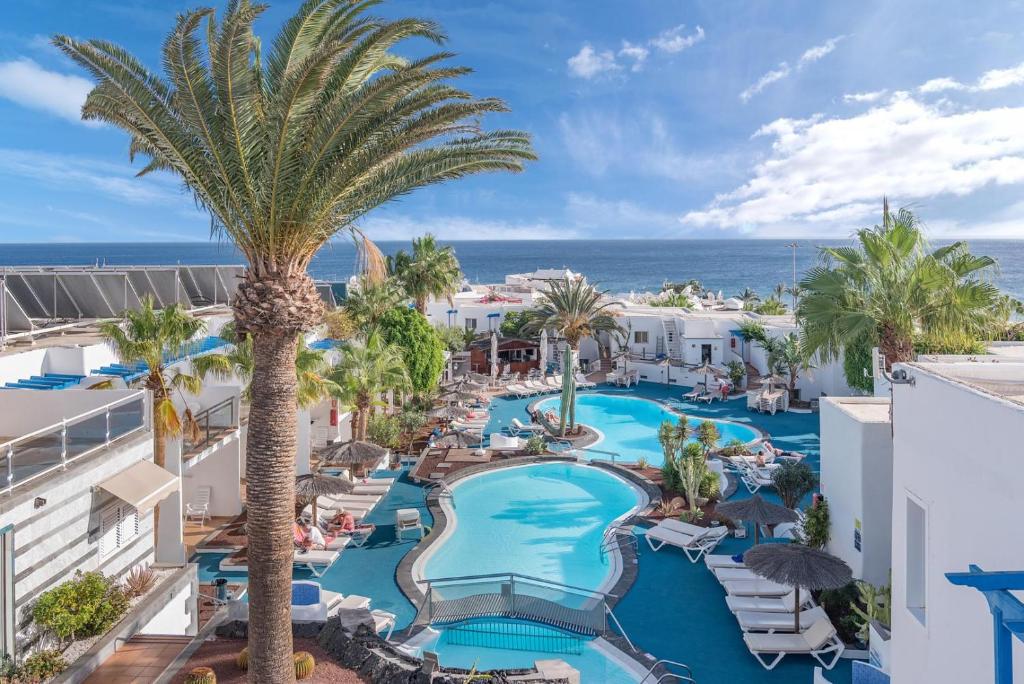 卡门港Apartamentos Parque Tropical en Lanzarote的享有度假村的空中景致,设有游泳池和棕榈树