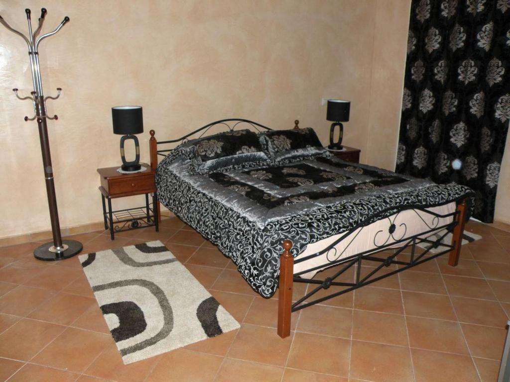 拉腊什Villa El Andalousse的一张位于带两盏灯和地毯的房间的床铺