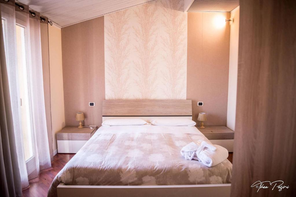 纳托Hotel Lonatino的一间卧室设有一张大床和两个窗户。