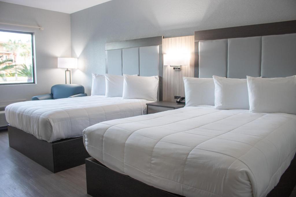 泰比岛Admiral's Inn on Tybee Island的酒店的客房 - 带2张带白色枕头的床