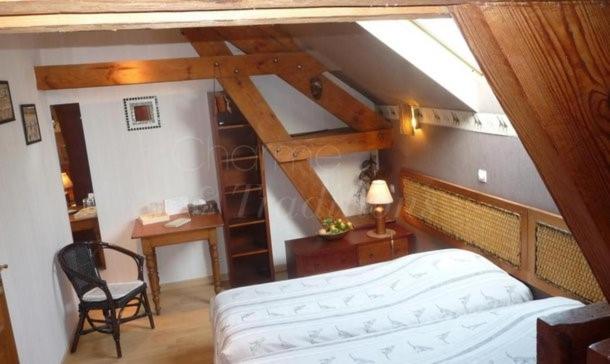 Biernegite du chêne的阁楼上一间卧室配有床和书桌