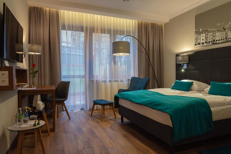 波兹南波兹南中心托帕兹酒店的酒店客房配有一张床铺、一张桌子和一张书桌。