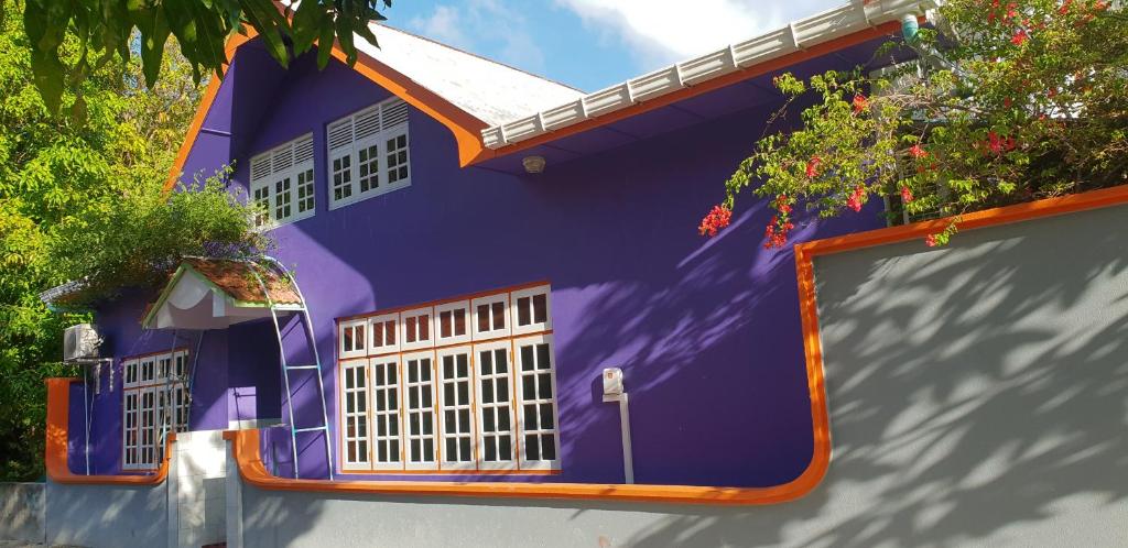 FuvahmulahFuvahmulah inn的一座紫色的房子,倒映在一座建筑中