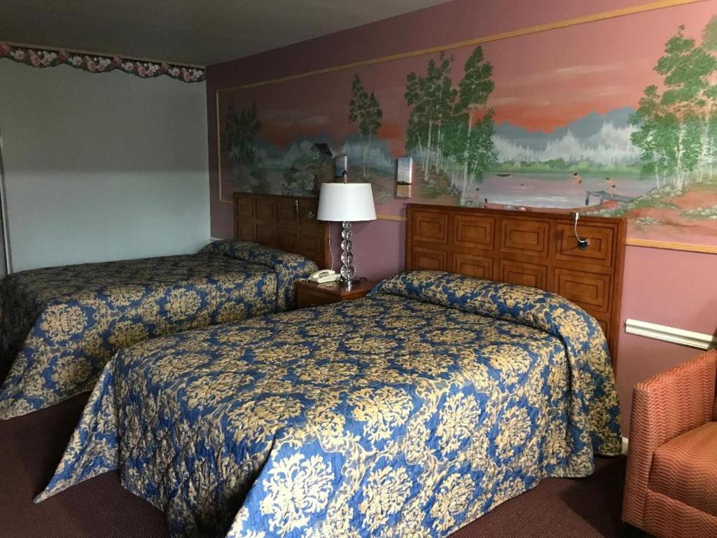 Lovingston乡村汽车旅馆的酒店客房,配有两张床和椅子