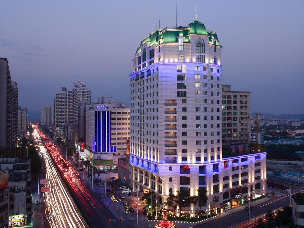 东莞东莞豪门大饭店的一座高大的白色建筑,上面有蓝色的灯光
