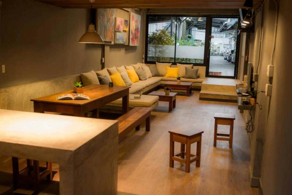 曼谷盒子旅馆的客厅配有沙发和桌椅