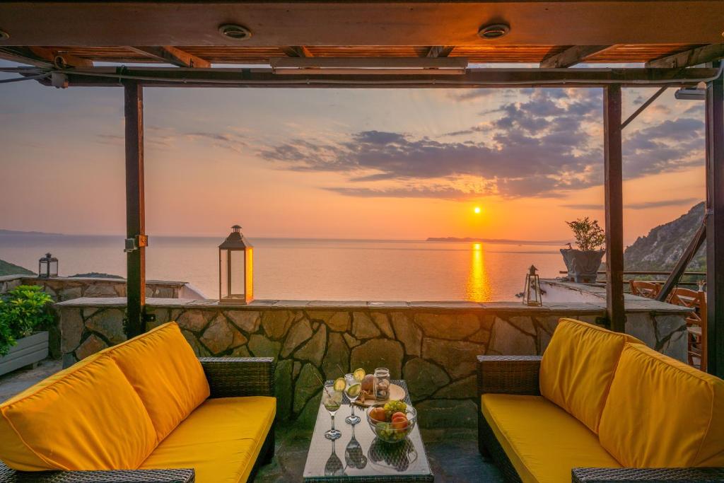 波帝卡Arilla Beach Hotel的天井配有两把椅子和一张桌子,享有日落美景