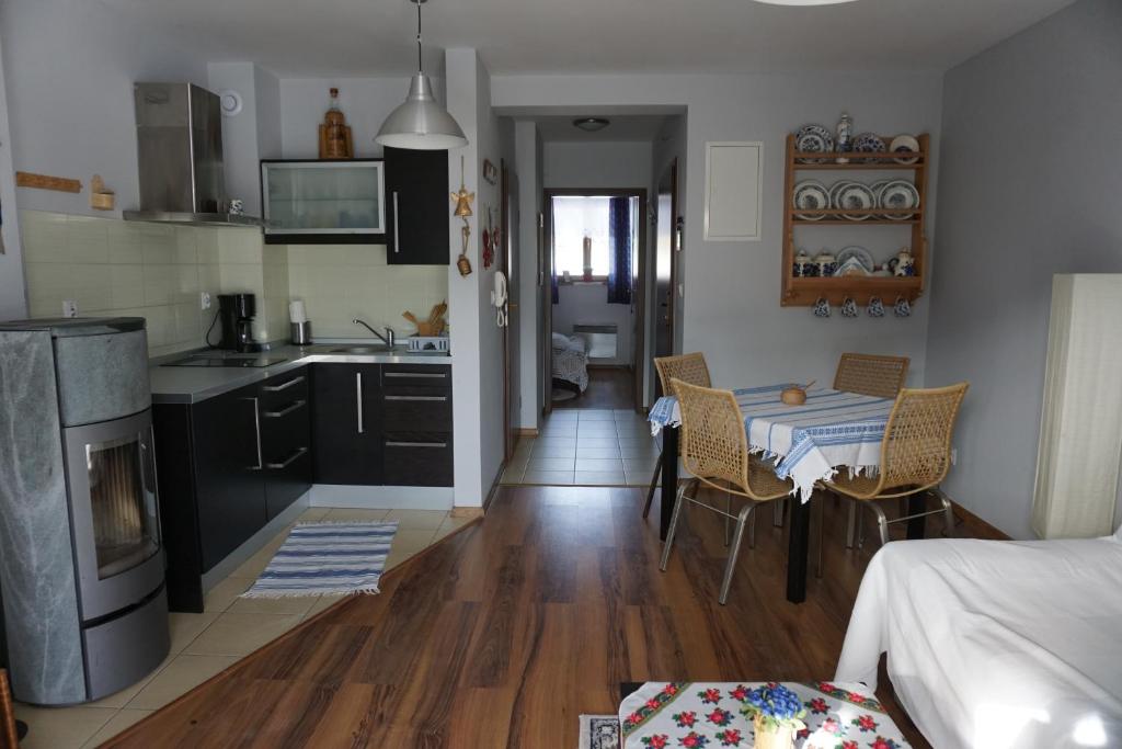 考斯赛力克Apartamenty z Basenem的厨房以及带桌椅的起居室。