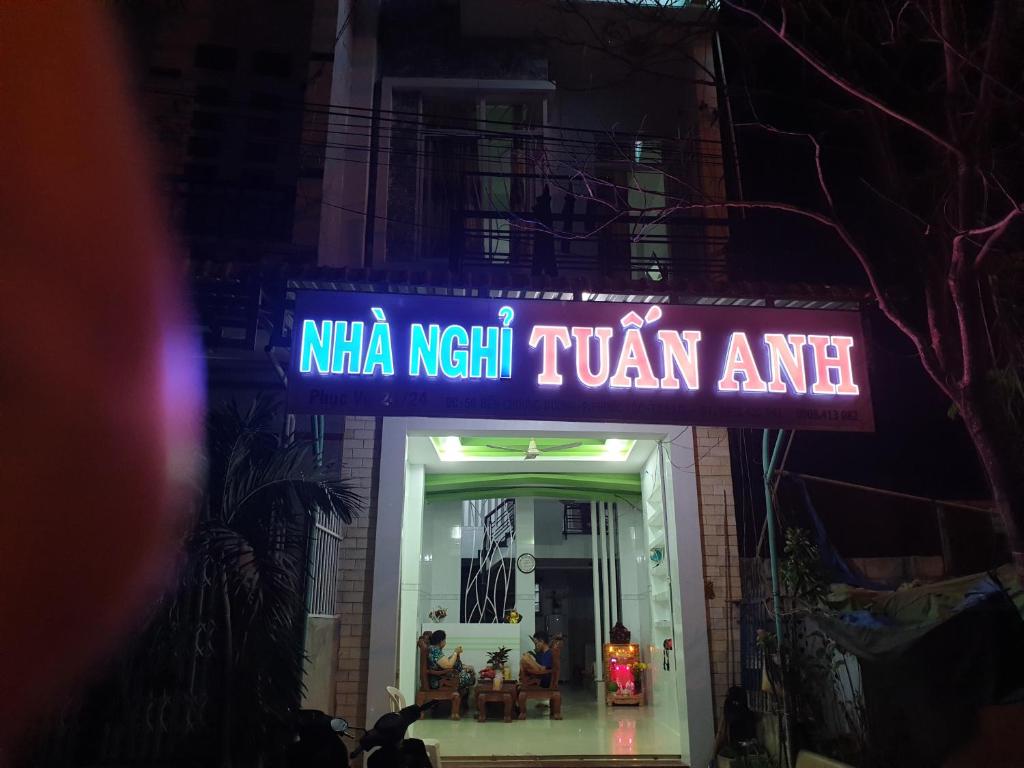 罗夷Tuấn Anh Motel的 ⁇ 虹灯标志,读一首尼凯什图米尔图米尔的建筑物入口