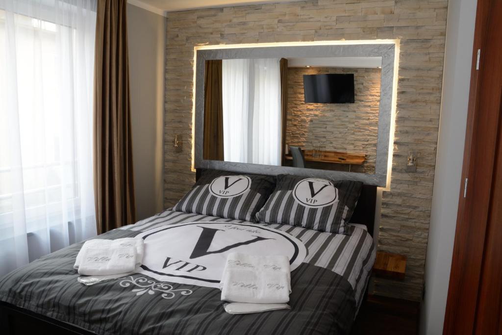格涅兹诺Villa Vip的一间卧室配有带枕头和镜子的床