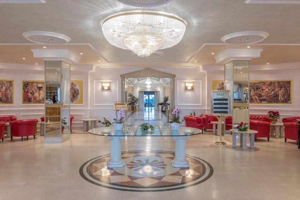 罗卡圣焦万尼美第奇别墅酒店的大堂配有桌椅和吊灯。