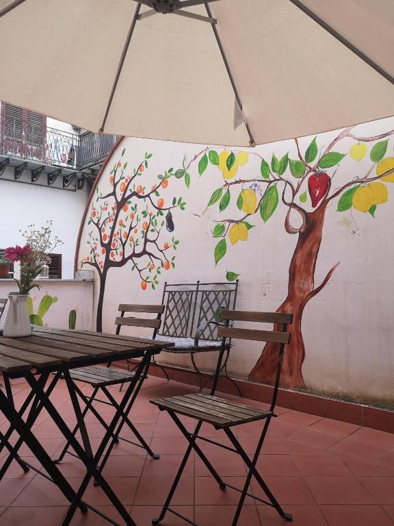巴勒莫Sunshine Hostel Palermo的墙上的苹果树壁画和桌椅