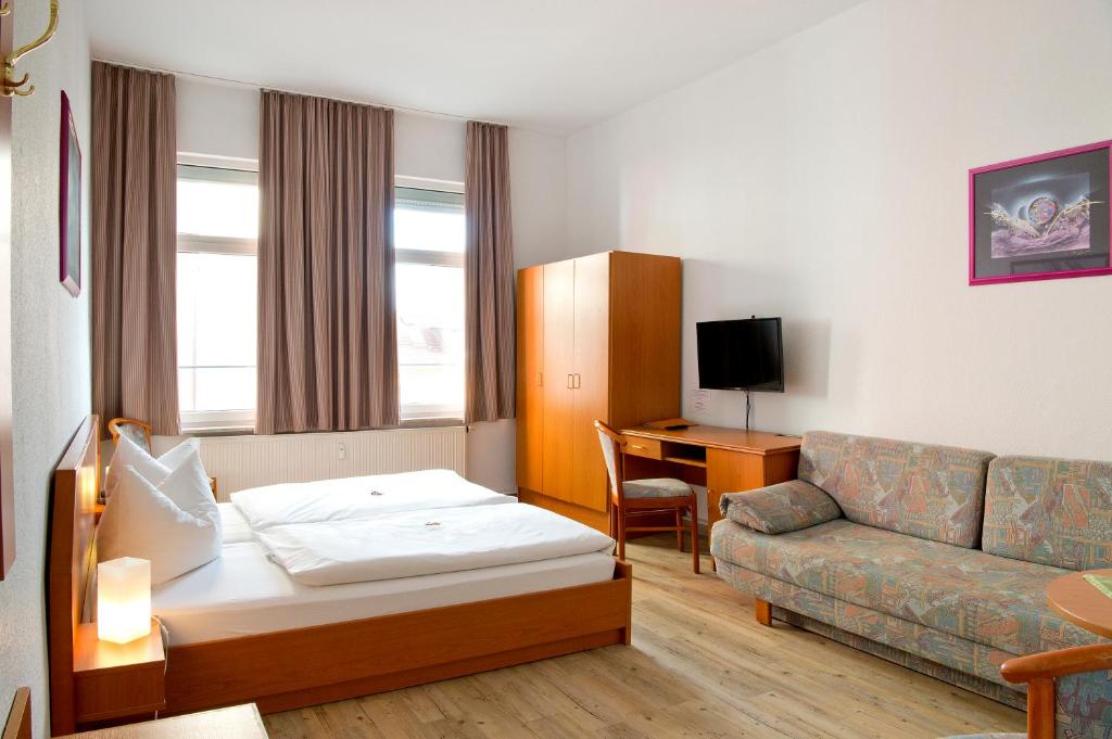 耶拿图林根霍夫酒店 的酒店客房,配有床和沙发
