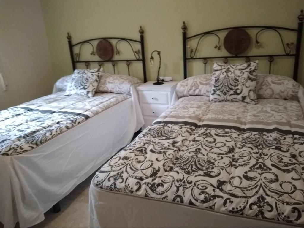 特鲁希略Apartamento Turistico La Victoria的一间带两张床和梳妆台的卧室