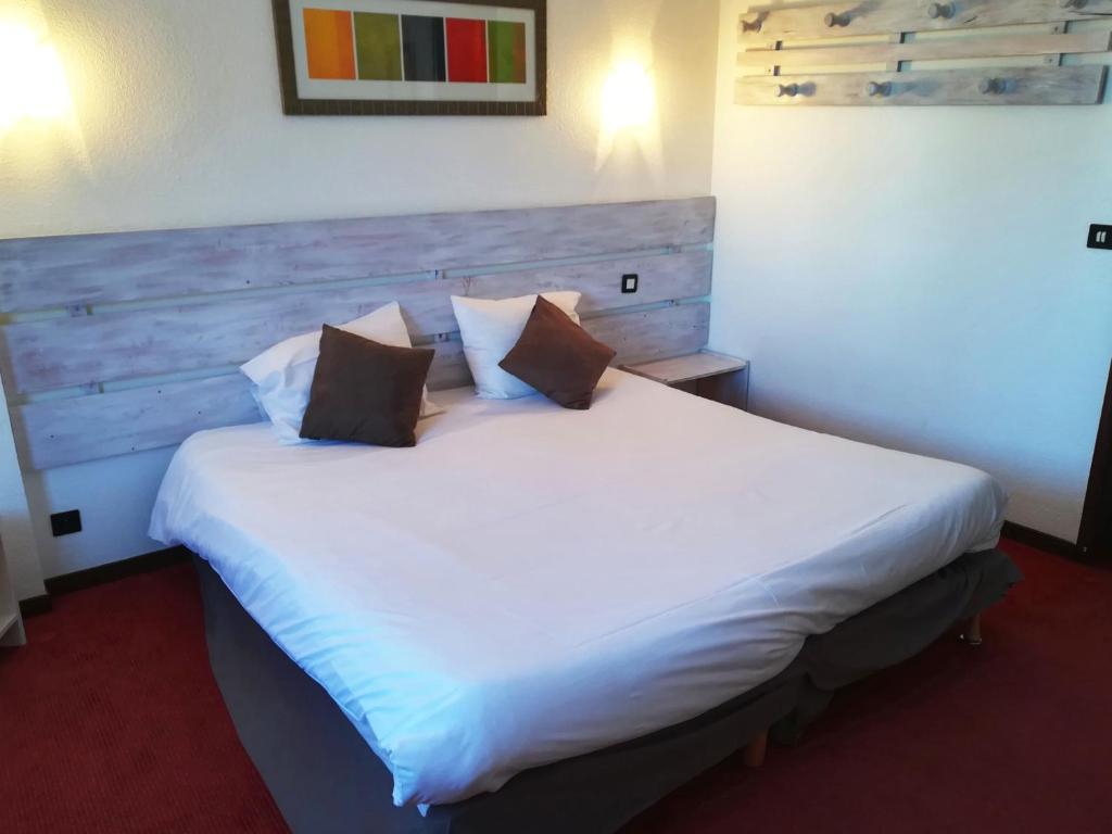 莱索尔莱斯艾克林斯酒店的卧室配有一张白色大床和木制床头板
