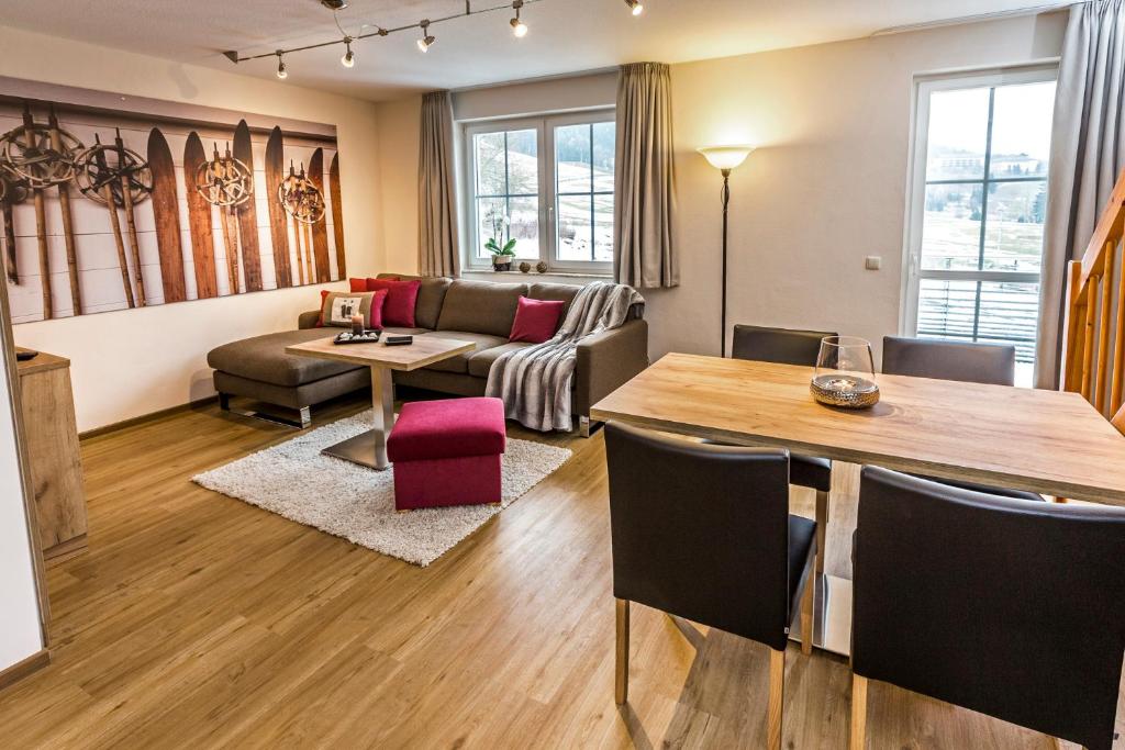 奥泊维森塔尔Simon´s Ferienwohnungen的客厅配有桌子和沙发