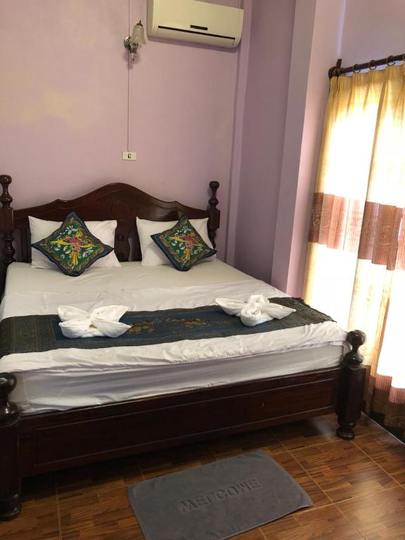 万荣索泰餐厅旅馆的一间卧室配有带白色床单和枕头的床。