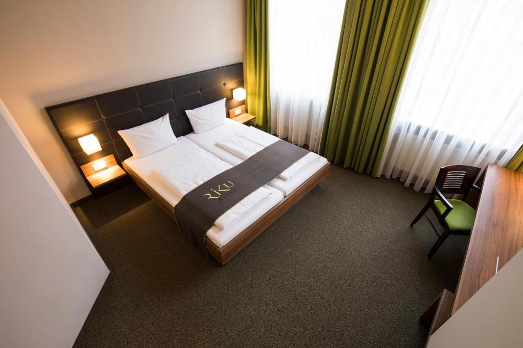 新乌尔姆新乌尔姆利库酒店的配有一张床和一把椅子的酒店客房