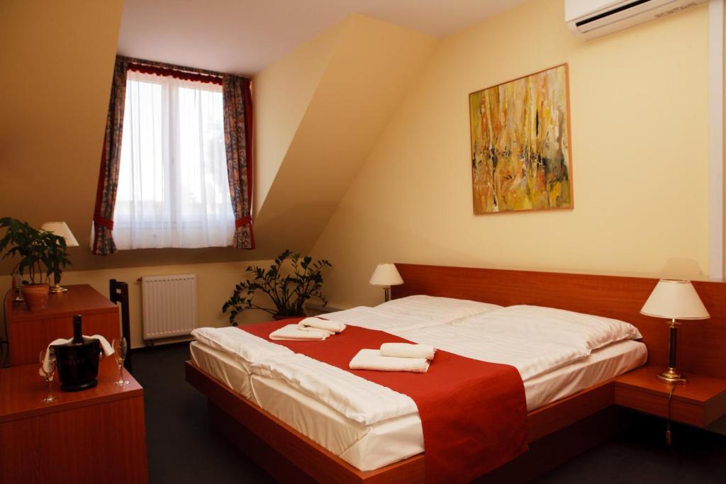 赛特古特哈德Lipa Hotel és Étterem的一间卧室配有一张床,上面有两条毛巾