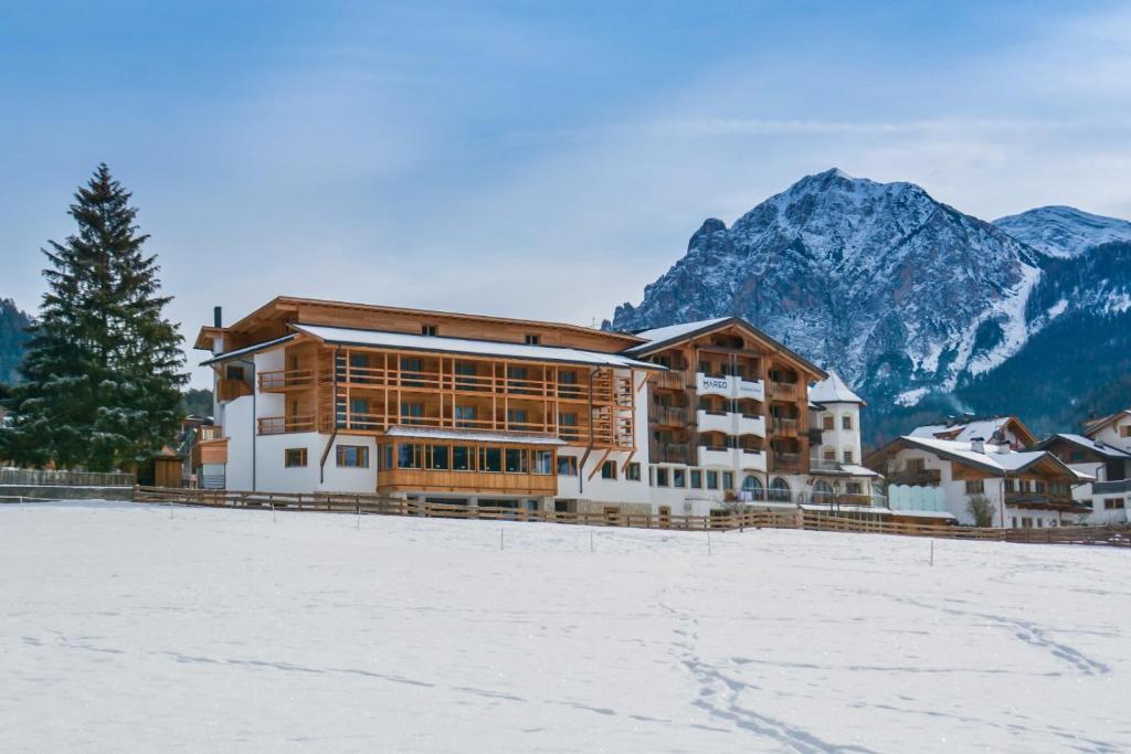 圣维吉利奥Dependance Hotel Mareo Dolomites的山前有积雪的大建筑