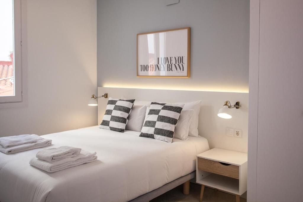 马德里Gran Central Suites的白色卧室配有床和镜子