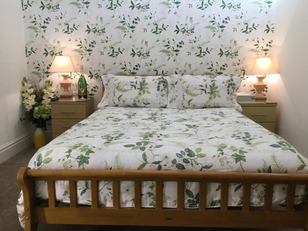 阿克灵顿Pilkingtons Guest House Accrington的一间卧室配有一张带花卉壁纸的床