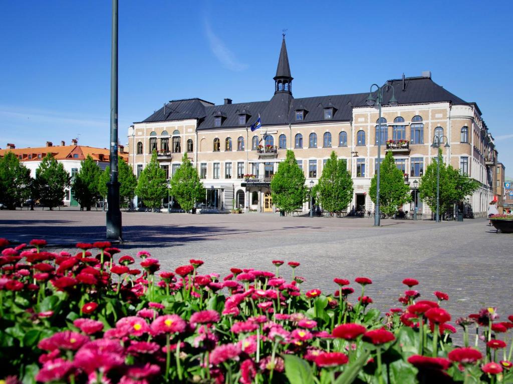 瓦尔贝里瓦尔贝里斯城市酒店及亚洲Spa的一座大建筑,前面有红花